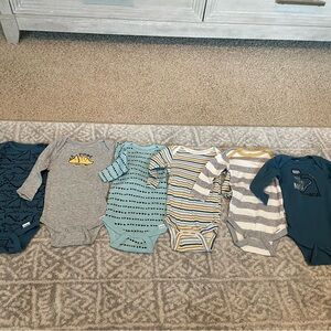 Six long sleeve dinosaur onesies by Gerber in a size 3-6 months